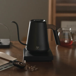 Hervidor eléctrico negro con pico estrecho y mango de madera para barista y accesorios de café de filtro de Timemore, todo sobre café.