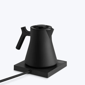 Hervidor de agua negro mate con mango ergonómico sobre placa calefactora, parte de Fellow, EspressoGear, todo sobre café