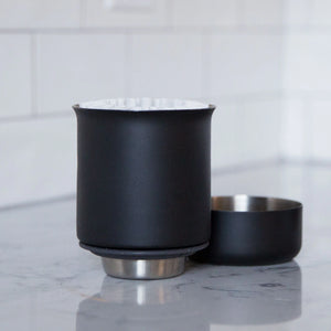 Molinillo manual negro mate con base plana y acero inoxidable, parte de Fellow y EspressoGear, todo sobre café.
