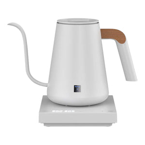 Hervidor eléctrico blanco con pico estrecho y detalle de madera en el mango, para barista y accesorios de café de filtro, todo sobre café.